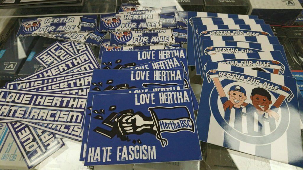 A vezető képen antirasszista üzeneteket ábrázoló matricákat láthattok a berlini Hertha BSC futballklubjának ajándékboltjában. Fotó: Bőtös Botond